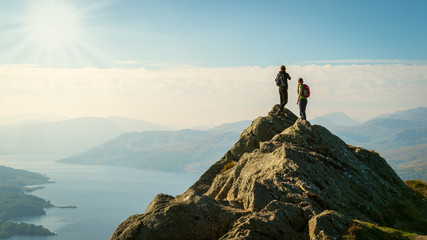 hikers on top of the mountain enjoying view, Highlands, Scotland - obrazy, fototapety, plakaty