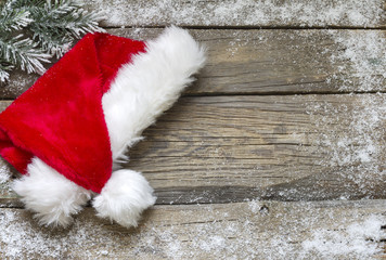 Obraz na płótnie Canvas Santa Claus hat on vintage wooden boards christmas background