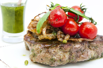 Grilled steak with sauce and greens on white background