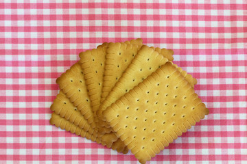 Classic crunchy biscuits on pink checkered cloth with copy space