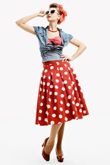 Pin-up young woman in vintage style trying on a sunglasses