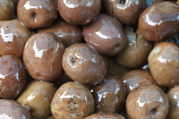 brownish olives in oil close up.