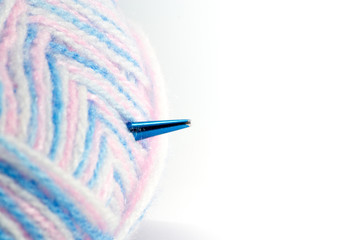 Knitting needles and yarn with space on the right side.