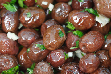 dark olives in oil with garlic and herbs close up