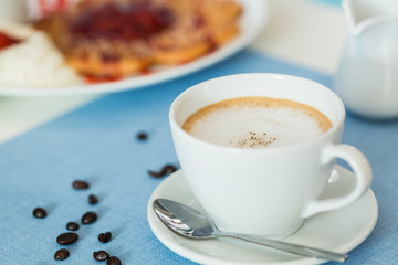 Cup of latte coffee on blue table