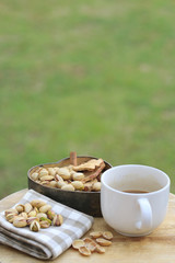 Pistachio nut and white coffee cup.
