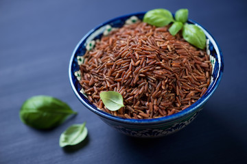 Close-up of a ceramic pialat with red rice kernels, studio shot