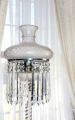Lamp in front of window bring on feelings of home and other nostalgic memories. Light has crystal base and hanging crystals.