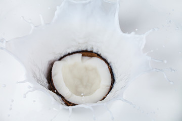 Coconut falling into milk splashes