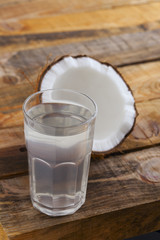 Coconut water and coconut fruit on wooden table