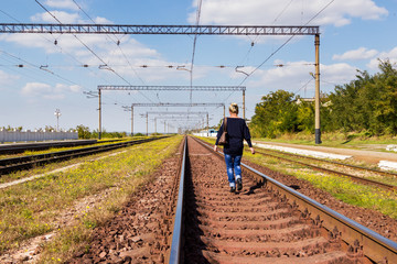 Naklejka premium Woman walking on railroad tracks