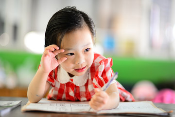 Cute Asian girl doing her homework.