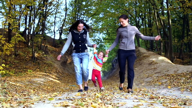 Mum walks with the child in the autumn forest.