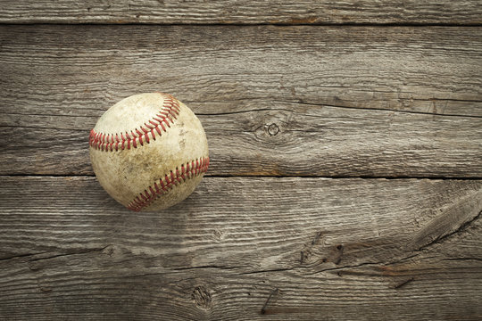 Old baseball on rough wood surface