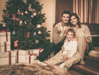 Happy family near Christmas tree in house interior