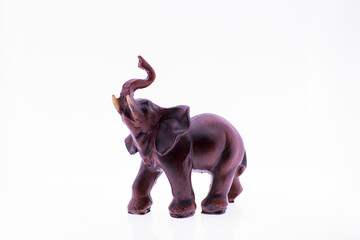 Elephant - brown figurine on white background with trunk up