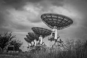 Stormy sky, radio dish array in black and white
