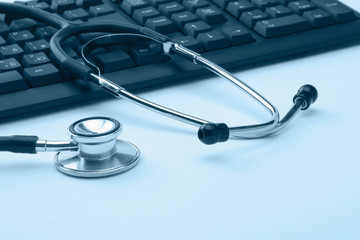 Stethoscope resting on a computer keyboard
