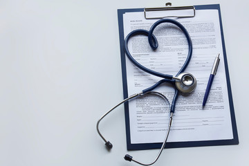 A stethoscope, a pen on a clipboard