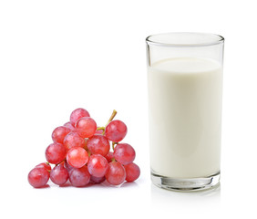 Glass of milk with grape over white background