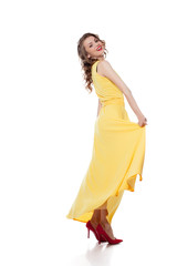 Happy young model posing in trendy yellow dress
