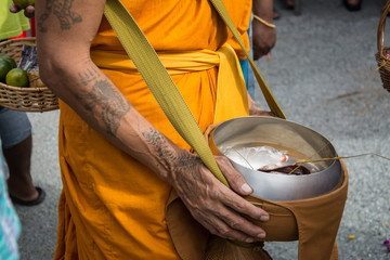 Buddhist monks are given food offering from people for End of Bu
