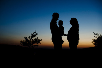 Obraz premium Silhouette of happy family in nature