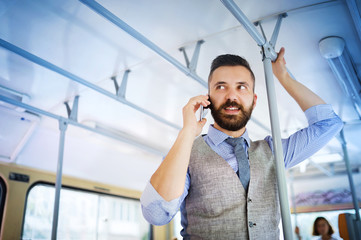Hipster businessman with mobile phone on tram