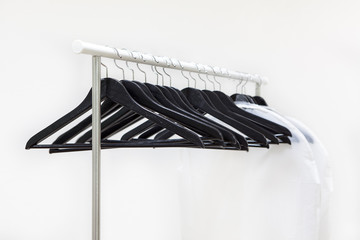 Empty rack with hanging black hangers and bags for clothes