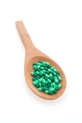 Fototapeta na wymiar Pills drug on wooden spoon isolated on white background