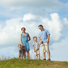 Fototapeta premium young happy family of four down from the mountains 