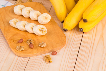 Banana slices on the wooden desk with nuts