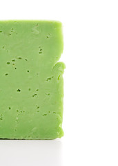 Green cheese with holes on a white background
