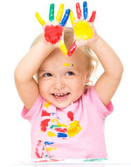 Portrait of a cute little girl playing with paints