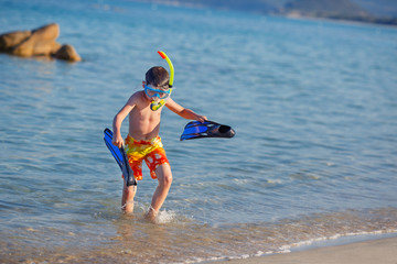 Boy with snorkeling equipment at tropical beach © levranii