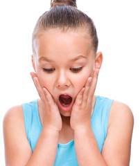 Cute girl is holding her face in astonishment