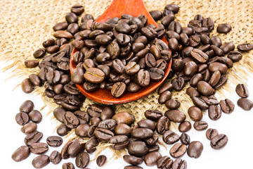 coffee beans on sacking and wood spoon, white background