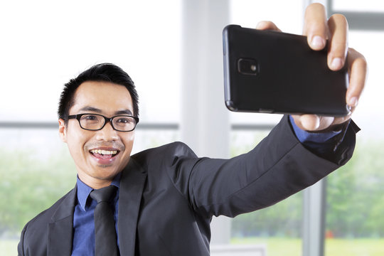 Businessman taking picture in office