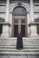 Fototapeta na wymiar beautiful dark vampire woman with black mantle and hood