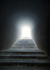 escalier dans le tunnel avec lumière au bout