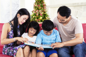 Two parents help their children to read