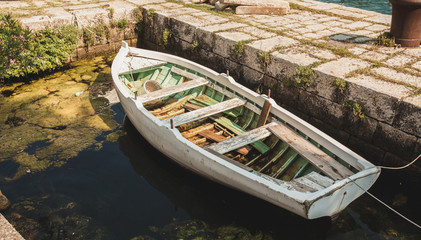 wooden rowboat mooring to ancient stone berth