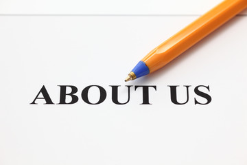 About Us text and ballpoint pen.