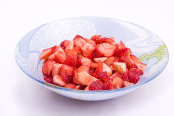 Клубника нарезанная кусочками в голубой тарелке