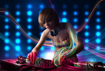 Young Dj girl mixing records with colorful lights