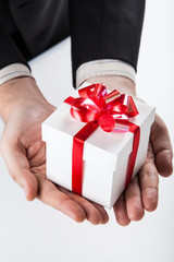 white gift box with red ribbon in hand