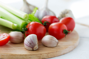 Cutting board with fresh vegetables on white wooden table