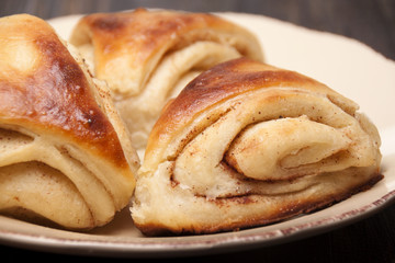 Buns from yeast dough with cinnamon on  dish  .