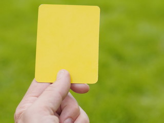 referee hand with yellow card