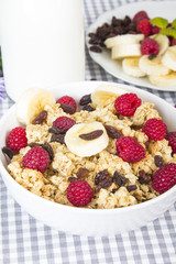 granola with fruits and bottle of fresh milk
